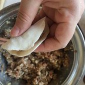 步骤图:加适量的肉馅儿在皮中央，对折捏紧即可。
