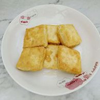 步骤图:待豆腐一面煎黄后再翻面，煎至两面金黄，出锅装盘待用